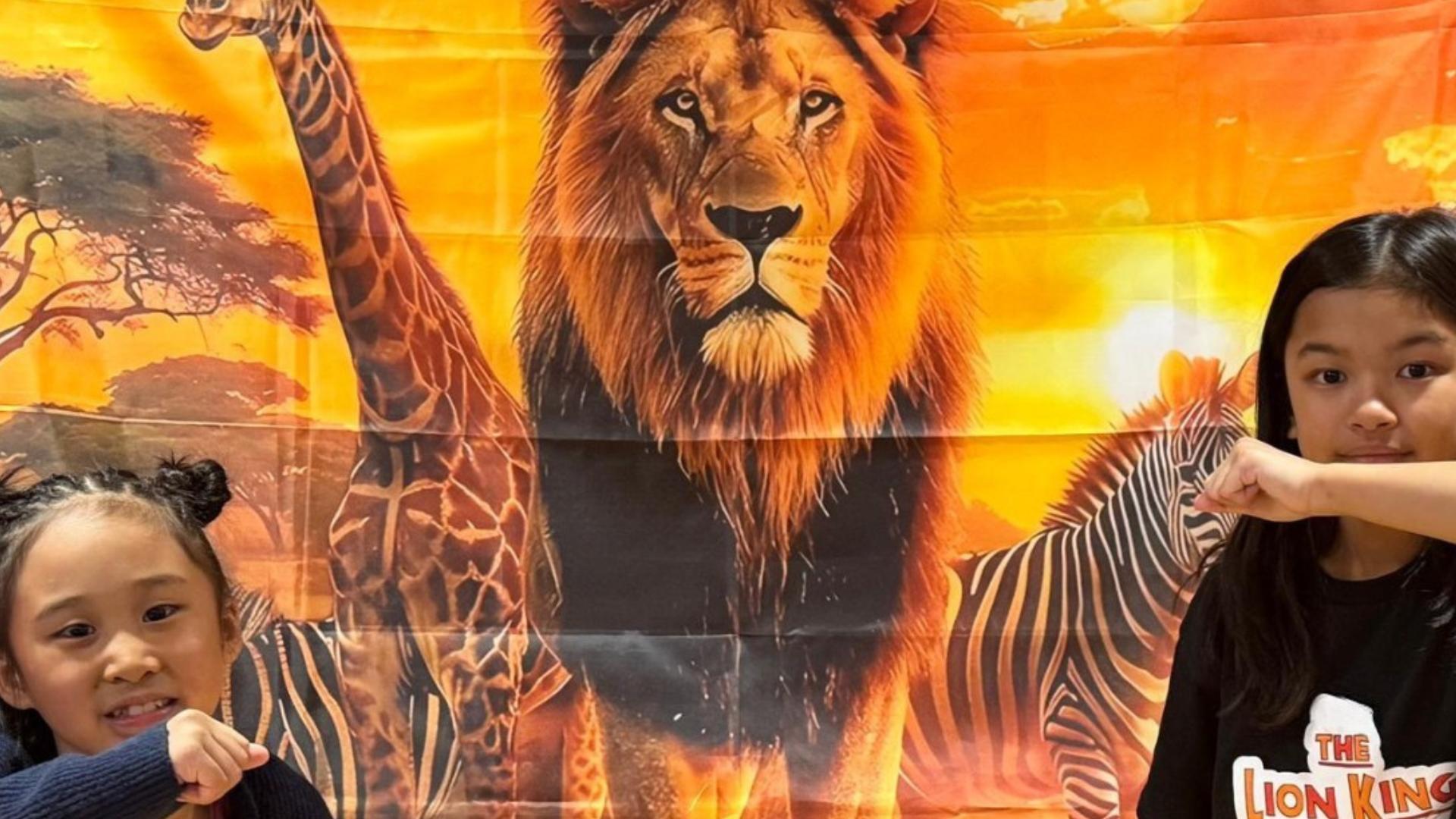 Children in front of the Lion's King Jr Theater Signage