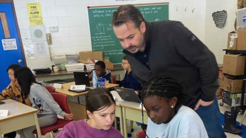 Students with their instructor working on their AI project