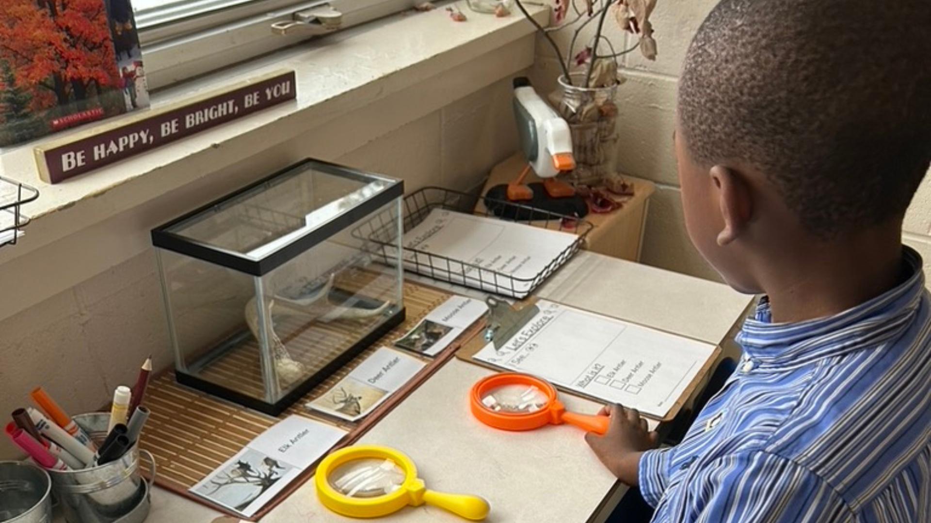 St. Monica's student with a magnifier in his classroom
