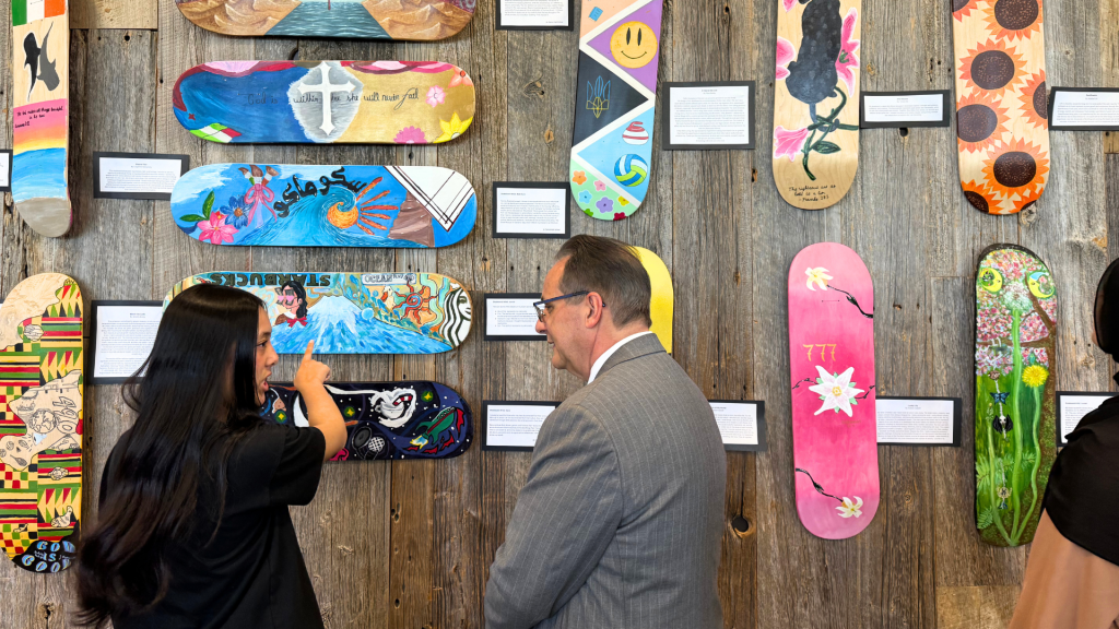 student explaining about the Be You project and their artwork to Tom D'Amico