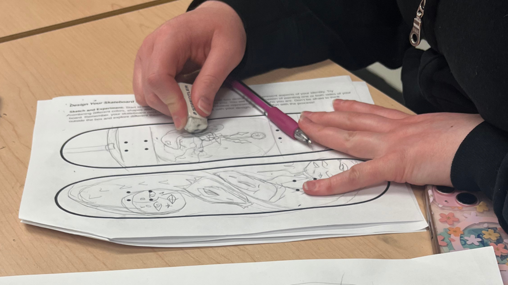 OCSB student making a sketch of their skateboard artwork