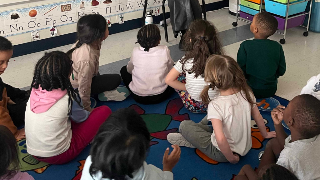 Students listening to Jacqi Du Toit telling a story