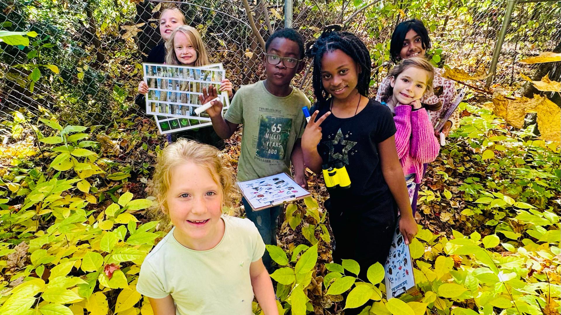 St. Monica's students showing their work in their Forest School