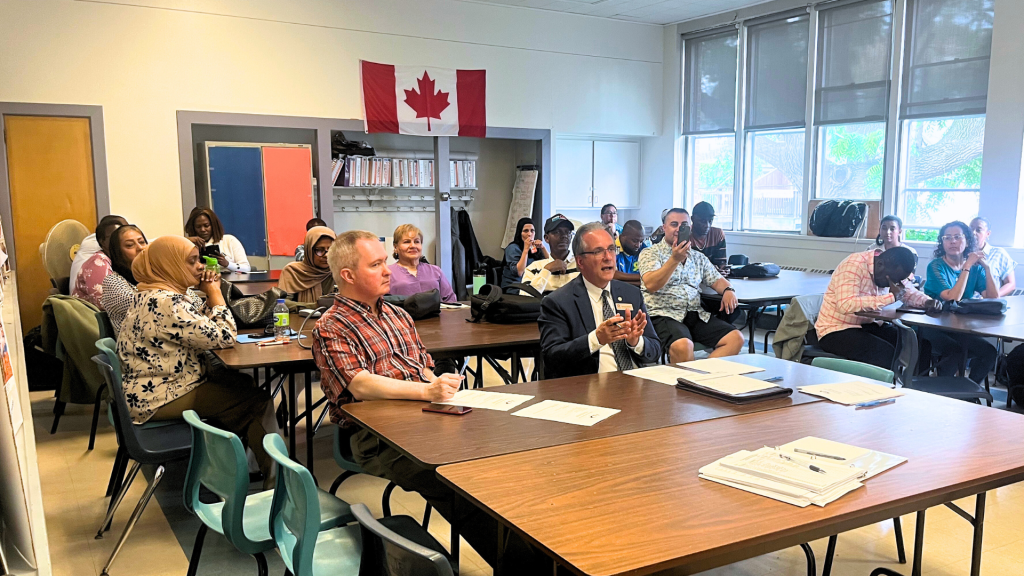 Tom D'Amico speaking with a few adult learners in the classroom