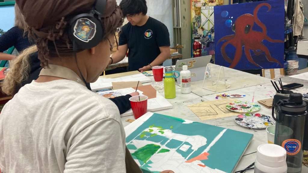 A student works on pieces that reflect shelter spaces and untold stories