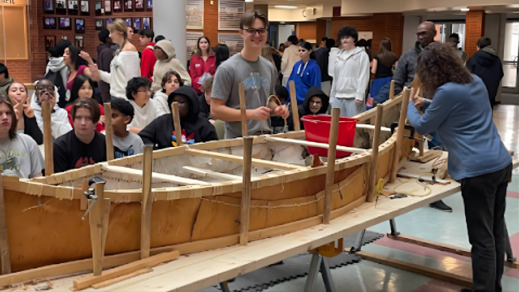 Students share with their peers the experience of making a canoe