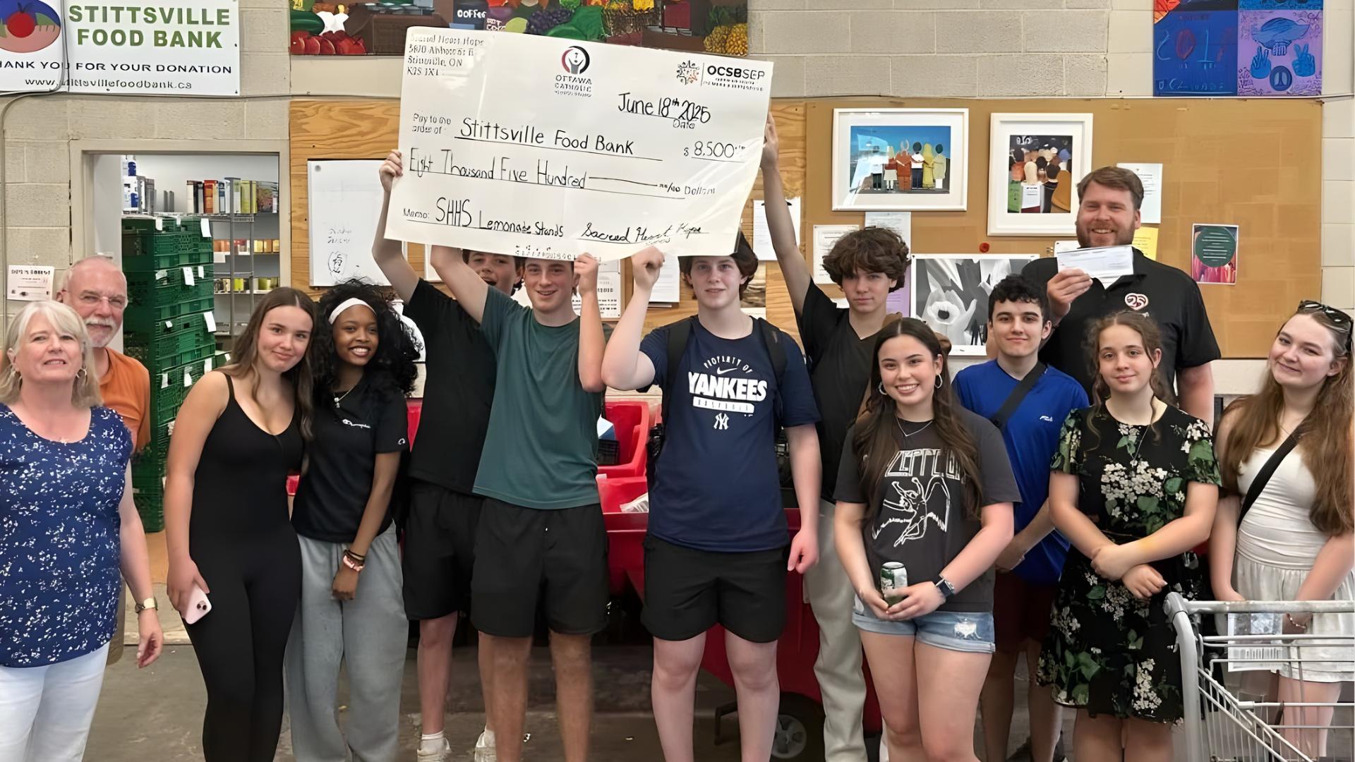 Sacred Heart students holding their donation cheque to Stittsville Food Bank