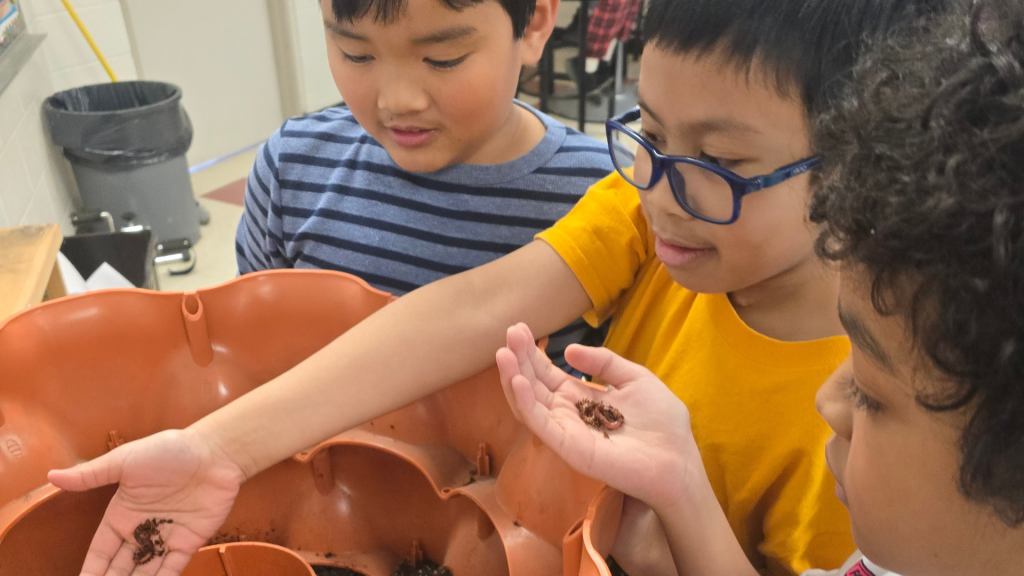 St Elizabeth students touching warms in their classroom experiment