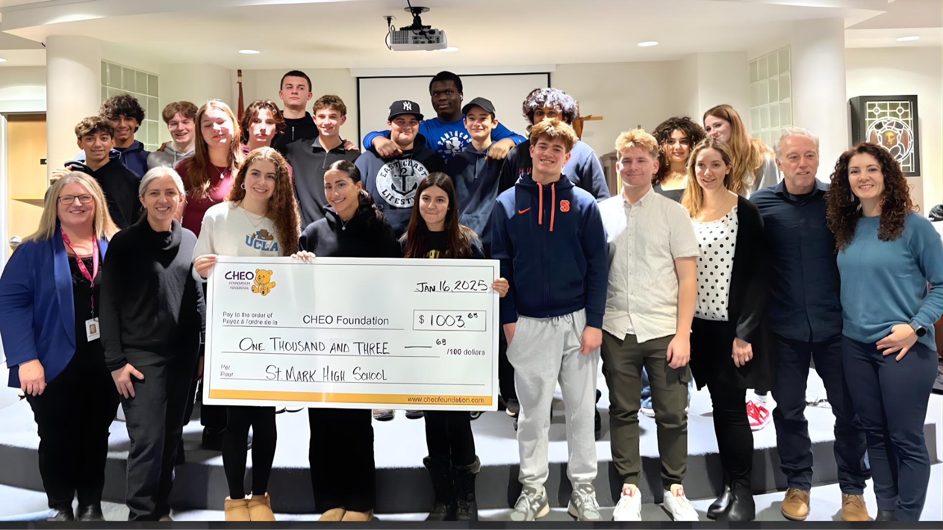 St Mark students holding the cheque to CHEO, a donation from their business